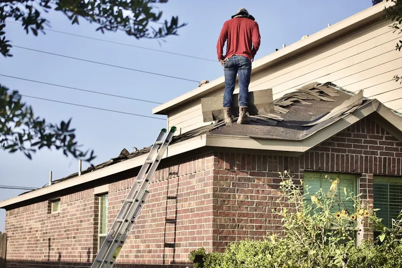 Professional roofer working on a residential roof in Rolling Woods